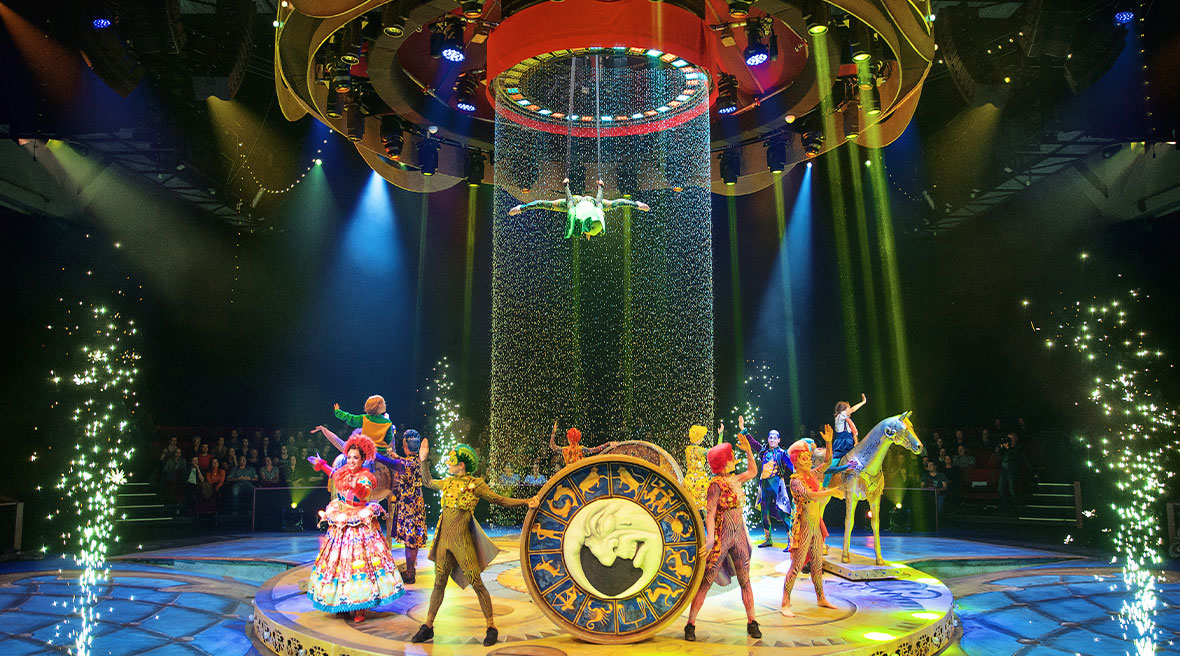Performers standing in a circle in costumes with lighting displays