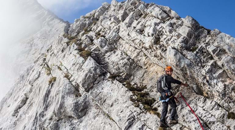 A rock climber ascending a cliff face 