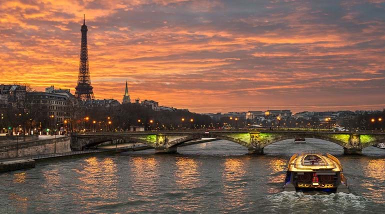 A view of a river in Paris at dusk