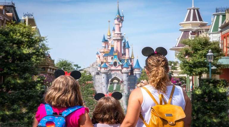 A family looking at a castle in a theme park